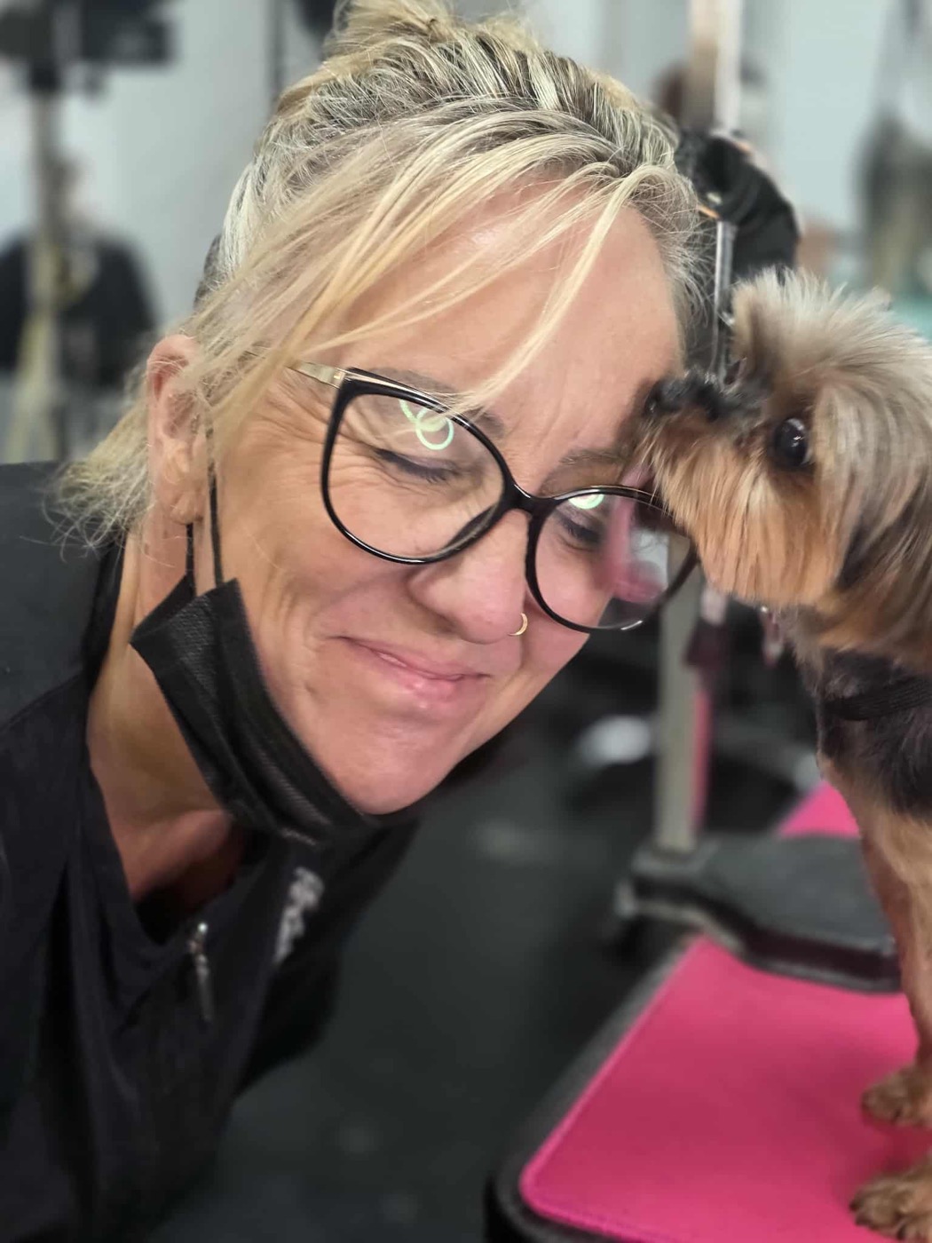 Jodie sharing a moment with a small dog during grooming
